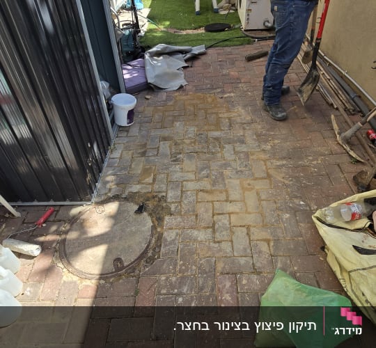 אדם עם את חופר ליד מכסה ביוב